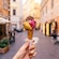 La mano de un Visitante sosteniendo un cono de gelato en medio de una calle de Civitavecchia